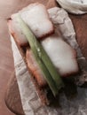 A slice of green onion atop two slabs of Ukrainian salo on bread Royalty Free Stock Photo